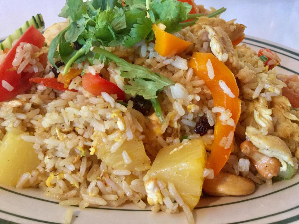 80. Pineapple Fried Rice · Stir fried steamed rice with pineapple, egg, onion, curry powder, cashew nut, raisin and bell pepper.