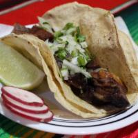 Lengua Taco · Broiled beef tongue. Tacos topped with fresh onions and cilantro, garnish with a lime wedge ...