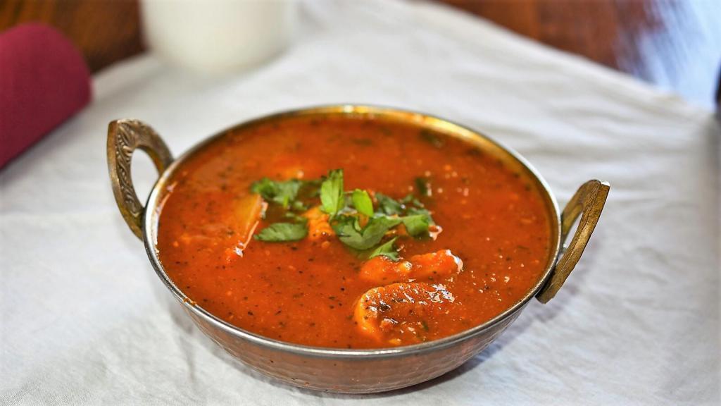 Shrimp Curry · A traditional Indian dish carefully seasoned with an exotic blend of curry spices, onion, garlic, ginger and tomato, in a medium-thick sauce. Served with basmati rice and your choice of a mild, medium or hot level of spice. Gluten free.