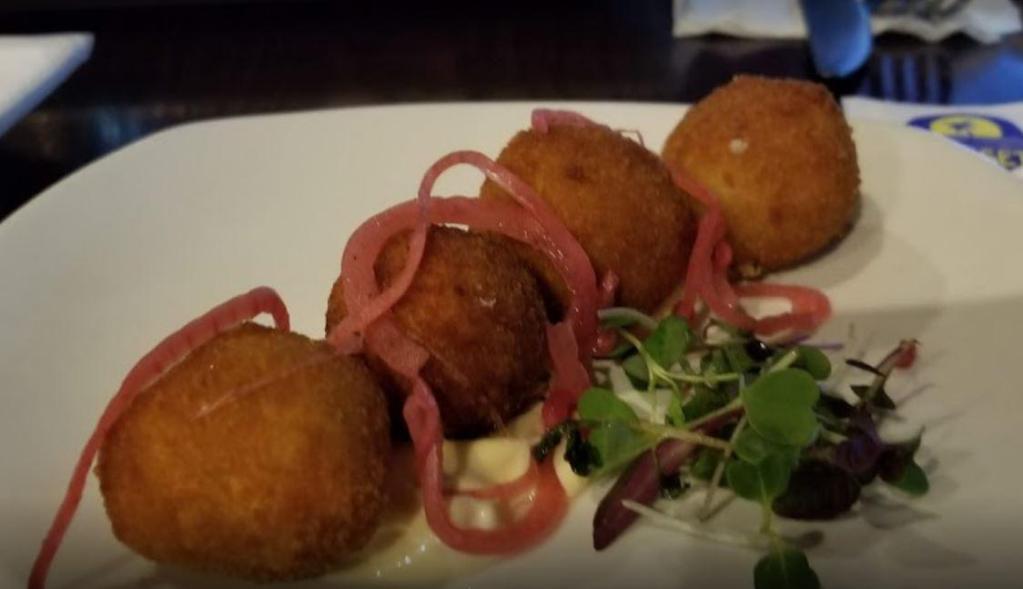 Goat Cheese Croquette Bites · Served with pickled red onion and garlic aioli. Vegetarian-friendly.