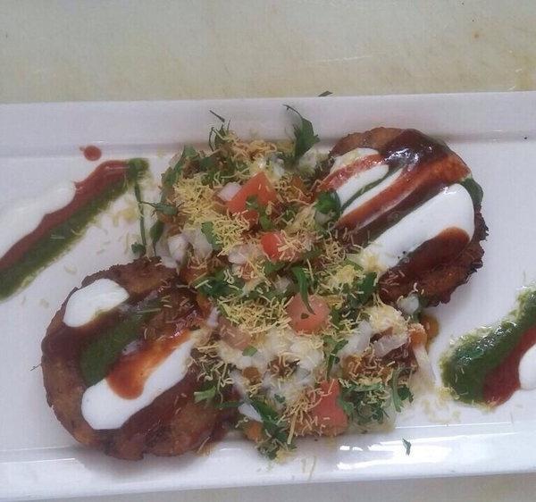 Aloo Tikki Chaat · Potato cakes served with chickpeas, yogurt, coriander and tamarind sauce and various indian spices.