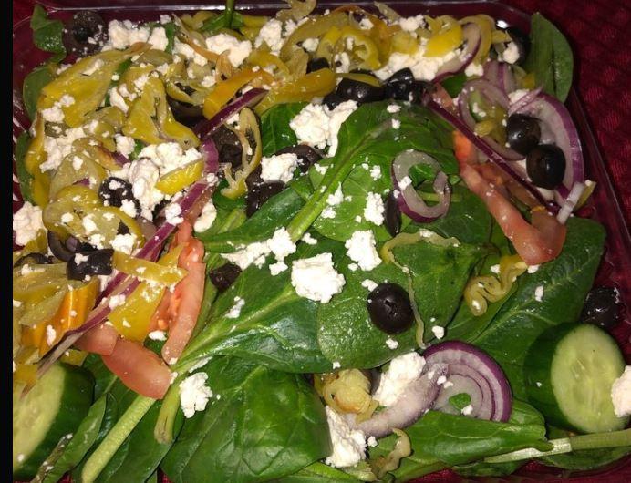 Greek Salad · Iceberg and romaine lettuce, tomatoes, red onions, cucumbers, black olives, feta cheese, and pepperoncinis.