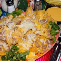 Super Nachos · A mountain of corn chips, smothered in melted jack cheese, beans, lettuce, tomatoes, grilled...