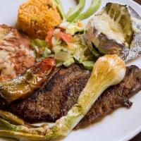 Steak Ranchero Dinner · 16oz top sirloin with onions, tomatoes and jalapenos. Includes beans, rice, baked potatoe, l...