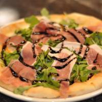 Capricciosa Pizza · Baked with prosciutto and mozzarella, topped with baby green salad and balsamic.