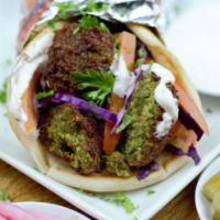 Falafel Wrap · Crispy vegetarian patties crafted from chickpeas, fava beans, herbs and spices wrapped in pi...