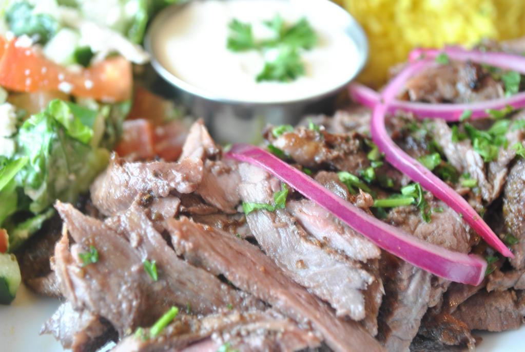 Beef Shawarma Platter · Thinly sliced top sirloin beef marinated in authentic house spices slowly roasted on vertical spit served with your choice of 2 side items, homemade garlic sauce and a warm pita bread.