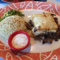 Mediterranean Lasagna Mousaka · Baked eggplant, potato, minced lamb and beef, tomato sauce, creamy bechamel. Served with bas...
