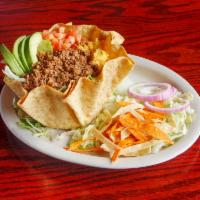 Fiesta Salad · Choice of ground beef or ranchero chicken on a bed of romaine and iceberg lettuce in a taco ...