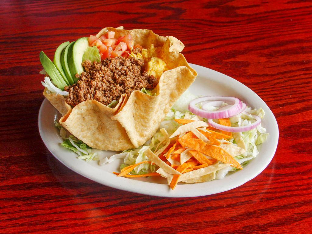 Fiesta Salad · Choice of ground beef or ranchero chicken on a bed of romaine and iceberg lettuce in a taco shell.