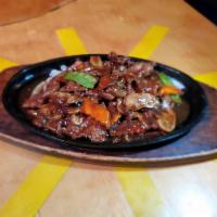 Sizzling with Black Pepper Platter · Stir fried with our chef special dark sauce with onion, black pepper, peas & carrot