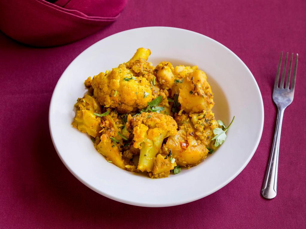 Aloo Gobhi · Potato and cauliflower sauteed with onions, tomatoes and Indian herbs.