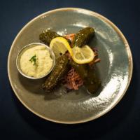 Stuffed Grape Leaves · Four meatless grape leaves hand rolled with brown rice and dill finished with lemon and oliv...