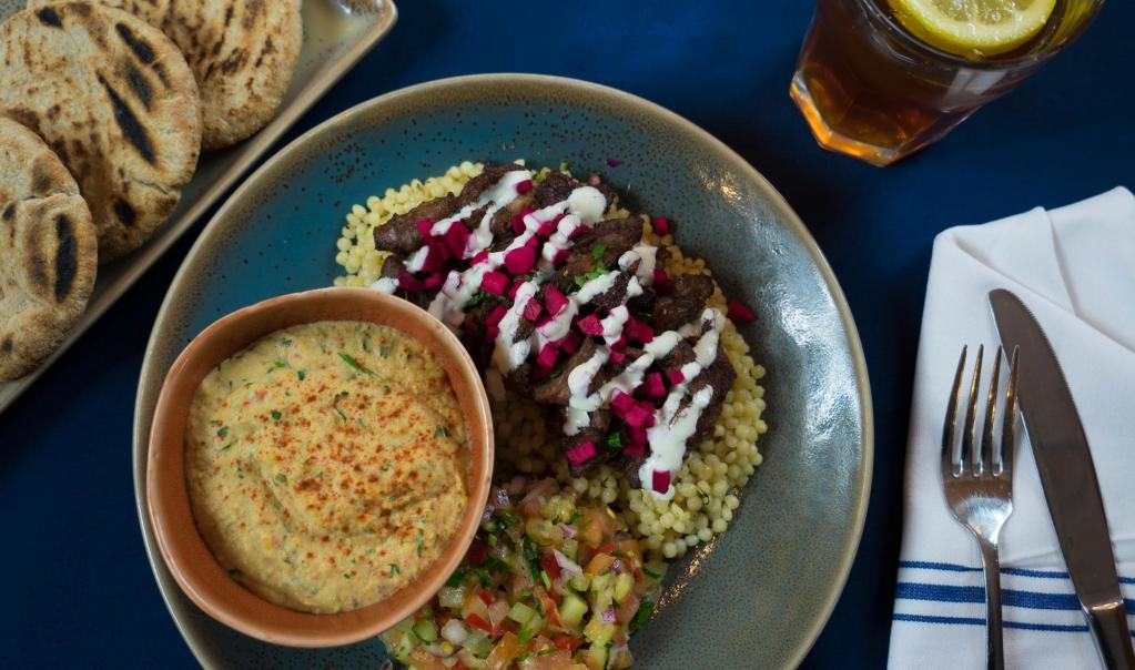 Lamb Shawarma Platter · Slow-roasted, marinated lamb with Israeli salad, brown rice, pickled turnips and your choice of dip or spread. Served with warm pita.