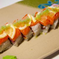 Sake Bomb Roll · Inside: spicy salmon and cucumber. Outside: salmon, sliced lemon, wasabi sauce and tobiko.