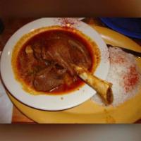 Lamb Shank · Tender bone-in lamb shank baked in a tomato sauce with carrots, potatoes and spices. Include...