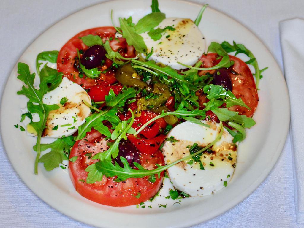 Caprese · Tomatoes, mozzarella, fire-roasted peppers, basil and extra virgin olive oil.

