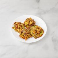 22. Tostones Mixtos · Carne, pollo y chicharron. Tostones with shredded meat, chicken and pork skin on top.