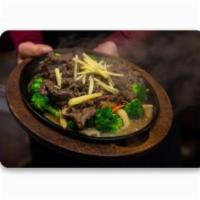 Siam Flaming Beef · Marinated beef, sesame seeds in hot plate, broccoli, mushroom and carrot. Served with jasmin...