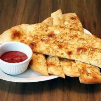 Parmesan Flatbread Sticks · Baked pizza dough topped with garlic butter and Parmesan cheese. Served with homemade marina...