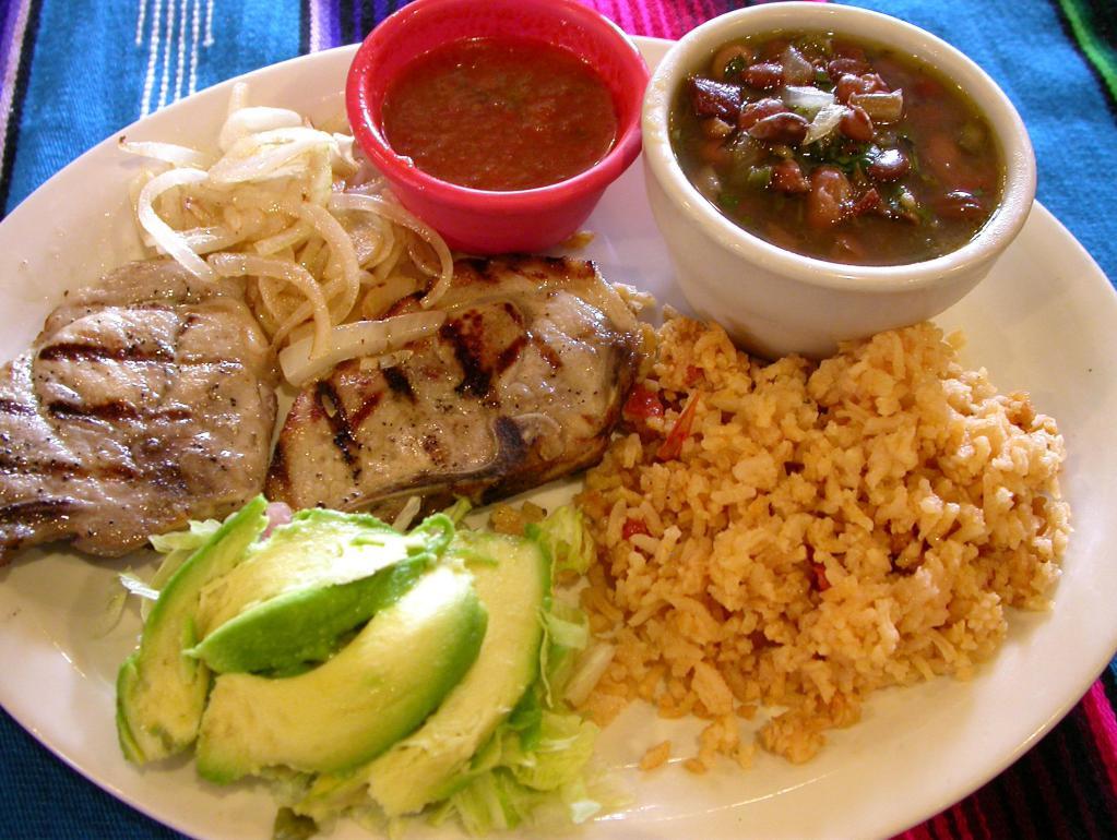 Pork Chop Plate · Two grilled pork chops served with grilled onions, rice, refried beans and salsa ranchera on the side. Served with charro beans, salad and homemade tortillas. 