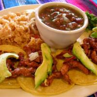 Trompo Tacos · Four corn tortillas filled with trompo, diced onions and cilantro. Served with rice, charro ...