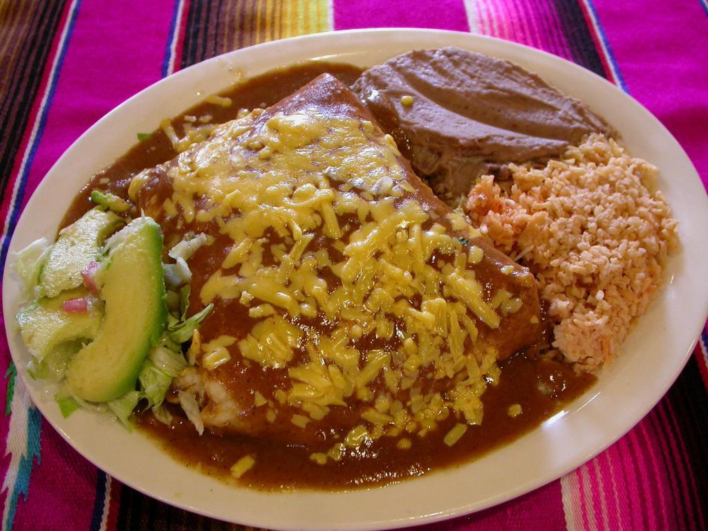 Texas Burrito Dinner · Chicken or ground beef and beans burrito smothered in special sauce and topped with cheese. Served with guacamole. Served with rice and refried beans. 