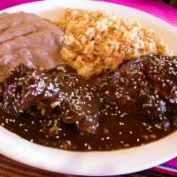 Chicken Mole Plate · Fresh pieces of chicken smothered with a rich mole sauce. Served with rice, refried beans, l...