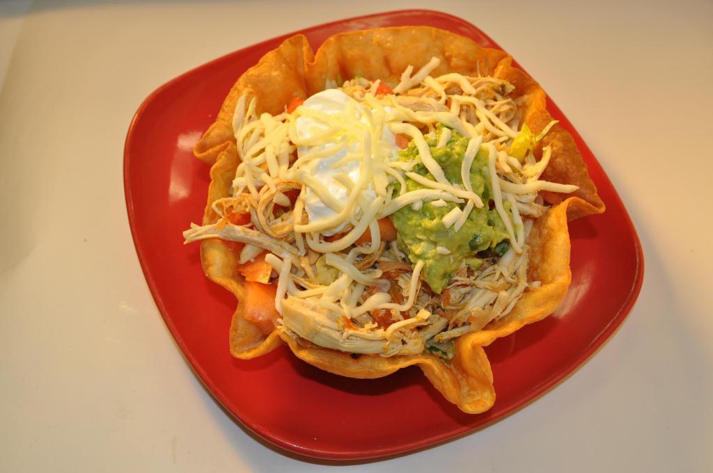 Taco Salad · Crispy flour tortilla bowl. Choice of beef, chicken or beef tips. Filled with beans, lettuce, tomatoes, cheese, sour cream and guacamole.