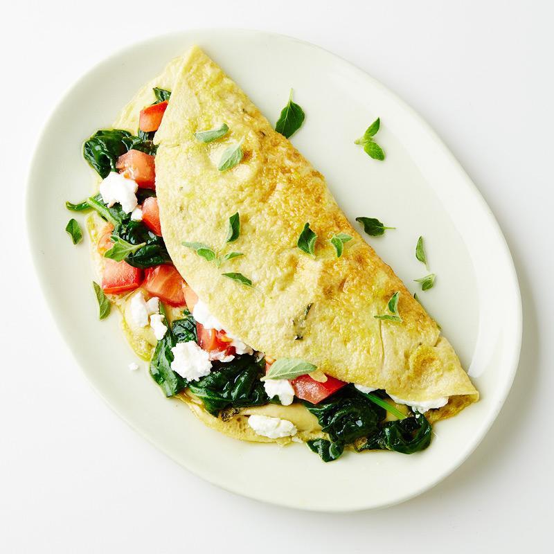 Greek Spinach Omelette · Sautéed spinach, fresh garlic, onions, scallions, dill in extra virgin olive oil, chopped tomatoes and feta cheese.