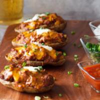 Mexican Potato Skins · Potato skins filled with chili and covered with melted cheddar and jalapeno served with sour...