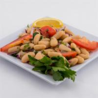 White Bean Salad · White kidney bean salad garnished with onions, tomatoes, parsley, and vinegar dressing.