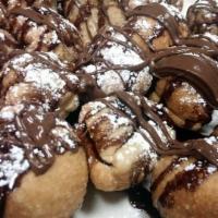 Nutella Dough Balls · Fried dough balls tossed in sugar topped with fresh Nutella and powdered sugar.