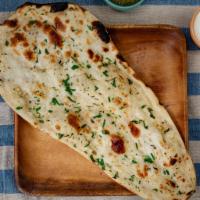 Garlic Naan · Leavened tandoor oven baked flat bread topped with garlic and cilantro.