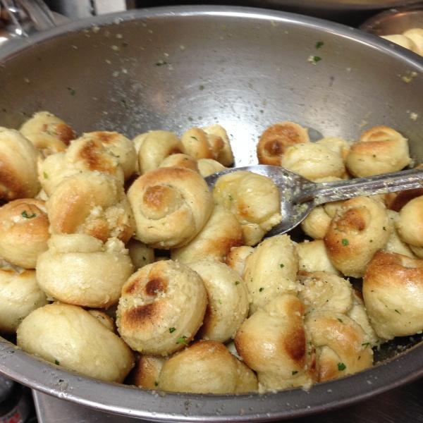 Garlic Knots · Knot-shaped pizza dough baked, tossed in olive oil and Parmesan cheese, and served with a side of homemade sauce.