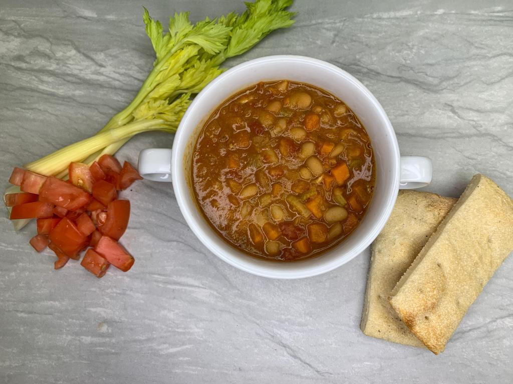 Spicy White Bean Soup · middle eastern spicy bean soup. white northern beans, celery, onions, plum tomato with a kick of spices (not that spicy hot) in a red broth. Served with homemade garlic bread.