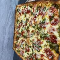 Grandma Pizza · Bed of mozzarella, dots of marinara sauce, pesto sauce, oregano and olive oil.