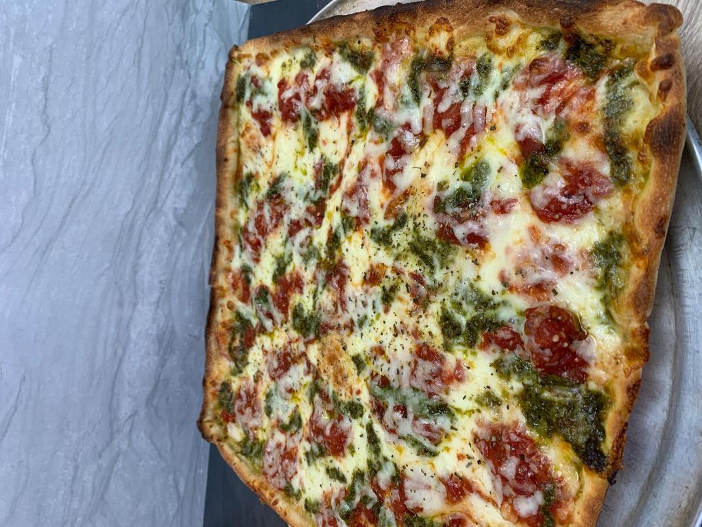 Grandma Pizza · Bed of mozzarella, dots of marinara sauce, pesto sauce, oregano and olive oil.