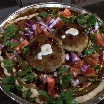 Aloo Tikki Chaat · Small potato patty with fresh tomatoes, onions, yogurt sauce, chickpeas, and topped with chutneys.