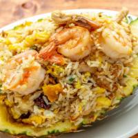 Pineapple Fried Rice · Fried rice mixed with egg, pineapple, chicken, shrimp and raisins served in a pineapple. 