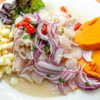 Ceviche de Pescado · Sliced fish marinated in spicy lemon juice. Served with sweet potato, fat corn, and canchita. 