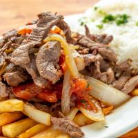 Lomo Saltado · Sliced beef chunks sauteed with red onions and tomatoes. Served over French fries.