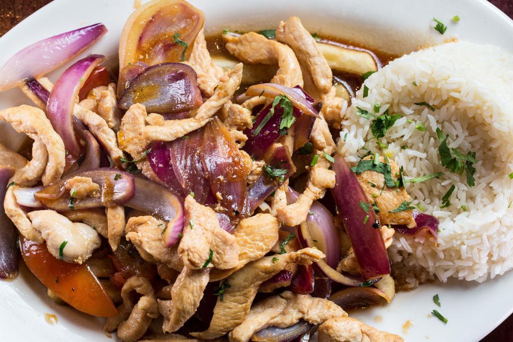 Pollo Saltado · Sliced chicken chunks sauteed with red onions and tomatoes, served over french fries.