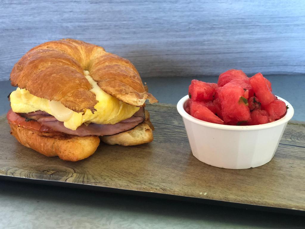 Toluca Croissant Sandwich · scrambled eggs, provolone cheese, shaved black forest ham, herb tomato, and dijonaise on a toasted croissant.