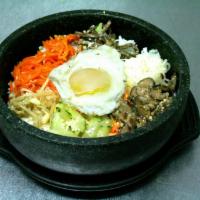 Gop Dol Bi Bim Bap Dinner · A bowl of warm rice topped with beef, an assortment of vegetables, and a fried egg on top. H...