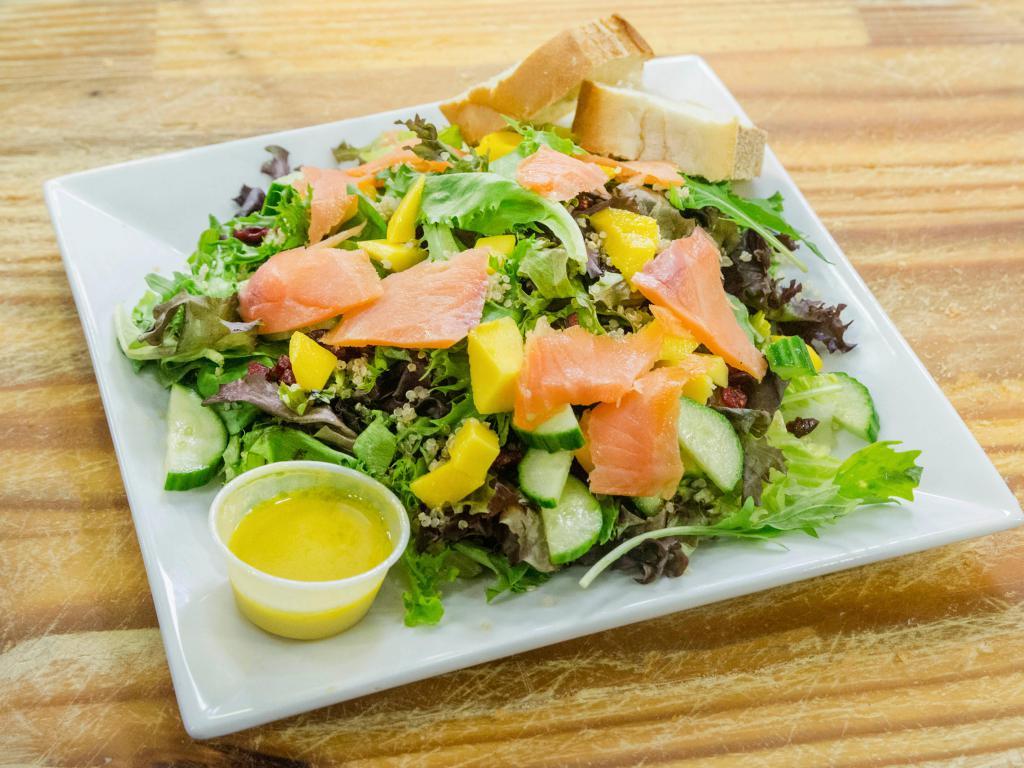 High Protein Salad · Spring Greens, Smoked Salmon, Quinoa, Cucumber, Dried cranberries, Avocado, and Mango. Served with honey citrus mustard dressing and bread.