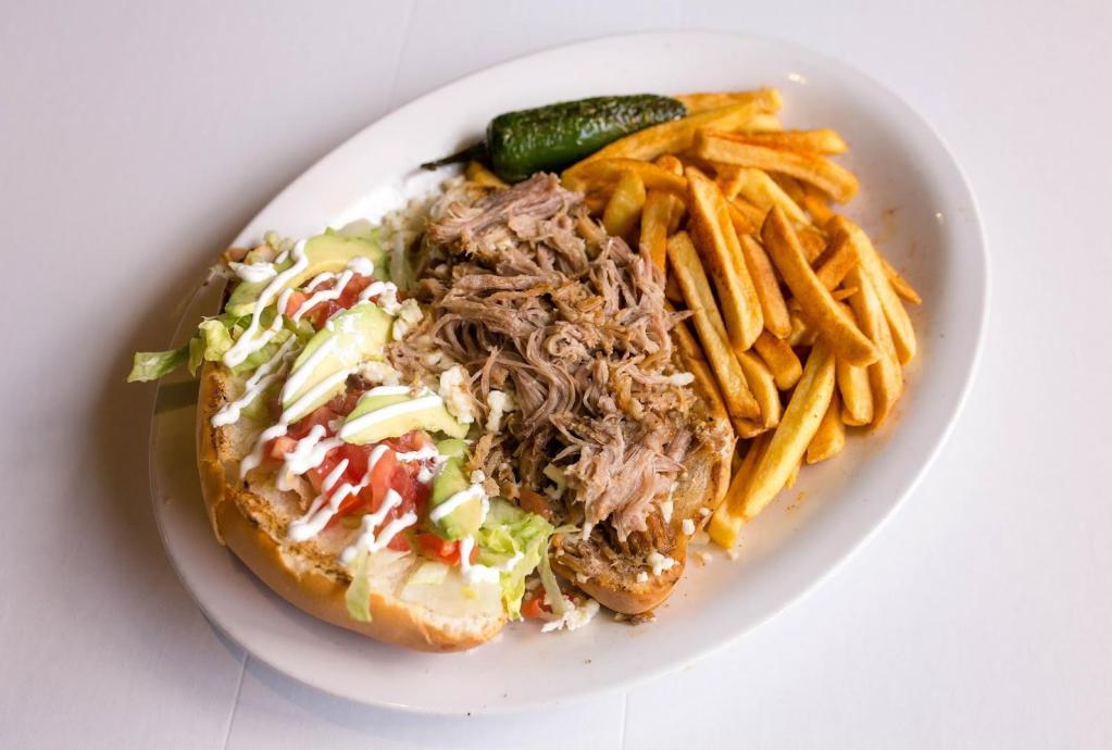 Torta Azteca · Mexican style poboy on toasted torta loaf bread, dressed with refried beans, queso fresco, tomatoes, avocados, lettuce, jalapenos, and crema. Served with french fries.