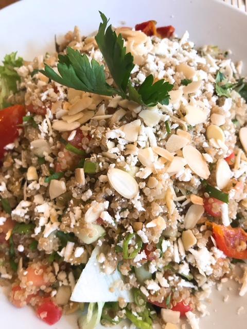 Quinoa Salad · Organic quinoa tossed with fresh diced tomatoes, cucumbers, finely diced green onions, chopped cilantro, roasted garlic, fire-roasted artichokes, feta cheese, toasted almonds in extra virgin olive oil and sweet lemon juice over baby greens. Gluten free.