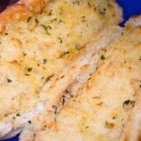 Garlic Bread · French style bread smothered generously with our in house garlic spread, then baked.