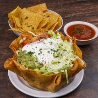 Taco Salad · A crispy flour tortilla bowl, filled with your choice of ground beef or chicken, with beans,...